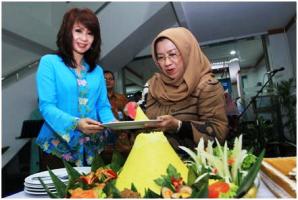 Presdir BCA Syariah - Yana Rosiana (kanan) memotong tumpeng dan memberikan kepada Pimpinan Kantor Cabang BCA Syariah Solo Lenny Herawati Tanty saat peresmian Kantor Cabang BCA Syariah Solo.