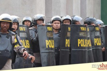 Polisi menangani pengunjuk rasa