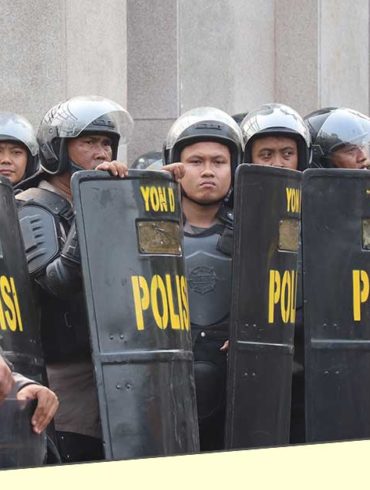 Polisi menangani pengunjuk rasa